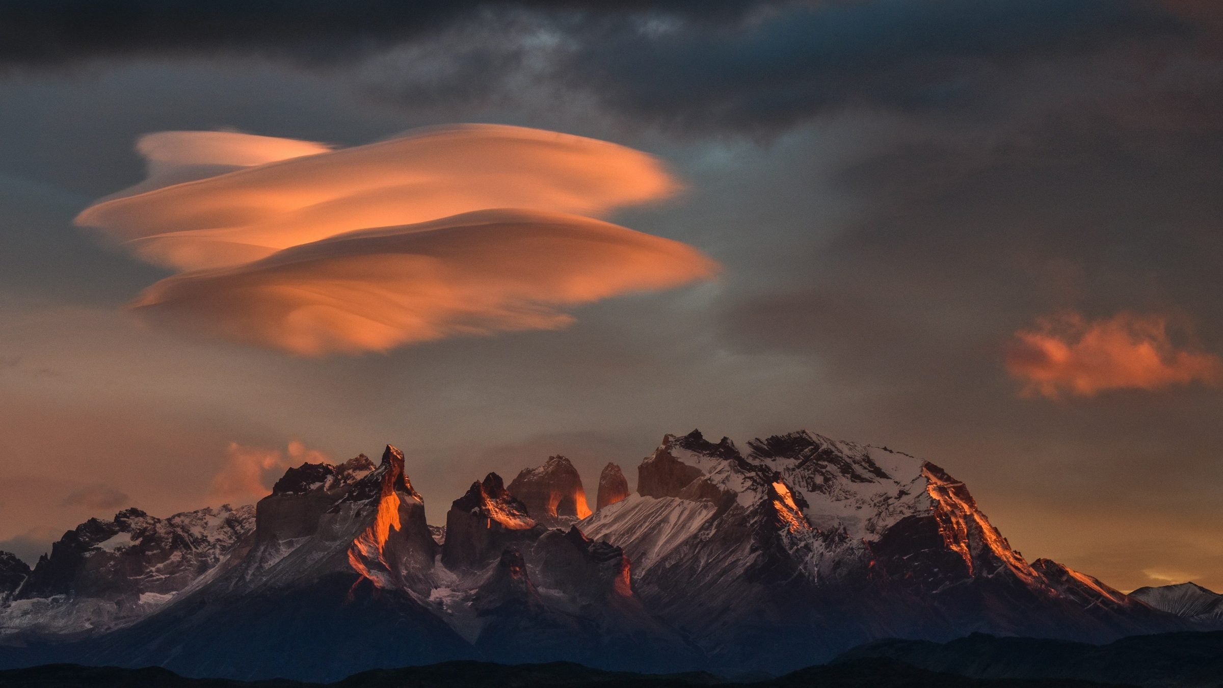 Lenticular cloud glowing orange at sunset above the Torres del Paine massif, Patagonia, Chile