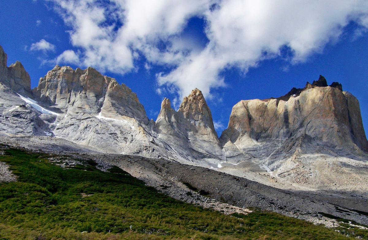 Dramatic granite spires and rock walls of the Cuernos del Paine massif in Chilean Patagonia under a blue sky