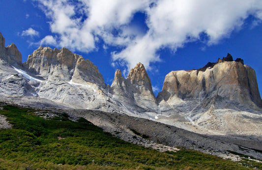 Dramatic granite spires and rock walls of the Cuernos del Paine massif in Chilean Patagonia under a blue sky