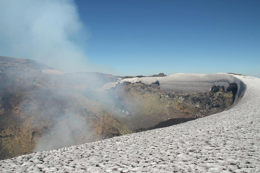 Steaming summit crater of Villarrica volcano in the Chilean Andes near Pucon, with snow on the rim and a deep blue sky