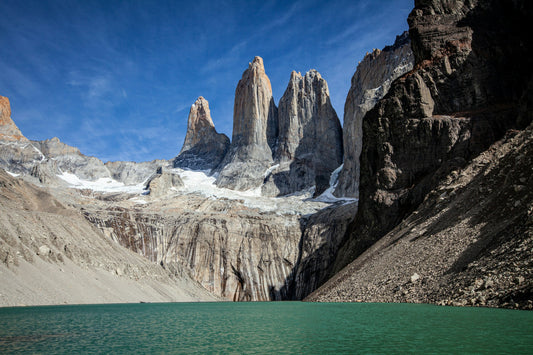 Three granite towers of Torres del Paine above a turquoise glacial lagoon, end of the W Trek