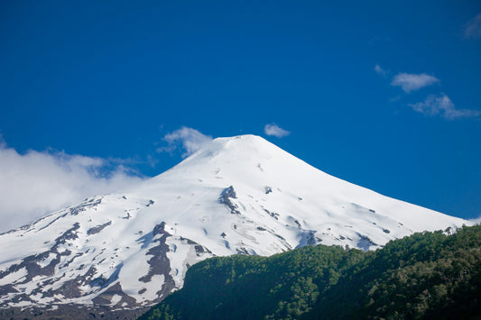 Snow-capped summit cone of Villarrica volcano under a deep blue sky near Pucón